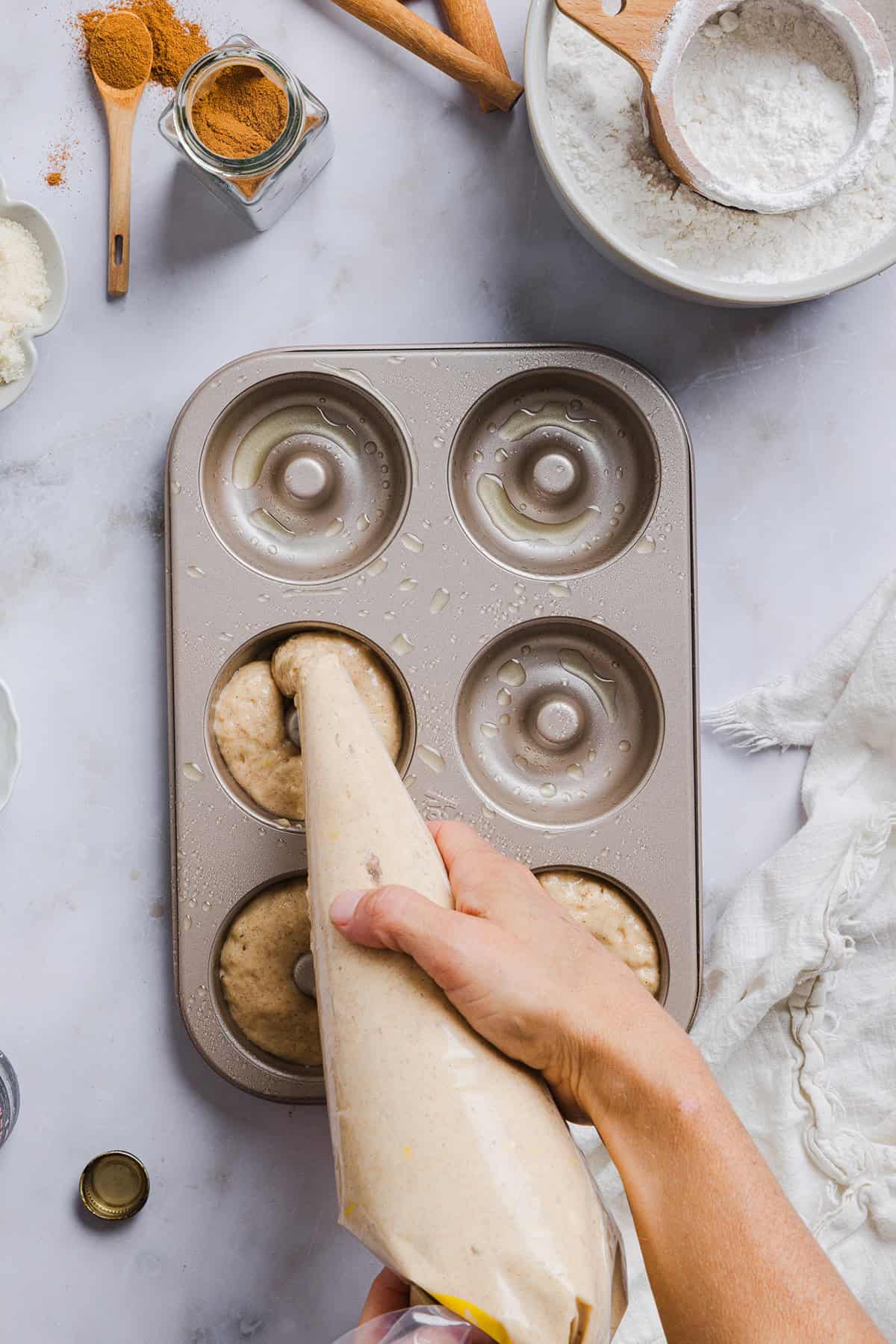 Soft Baked Apple Cider Donuts made healthier with whole wheat flour, applesauce and Greek yogurt for the perfect fall treat that comes together in just 20 minutes!  Loaded with warm spices and coated with cinnamon and sugar!