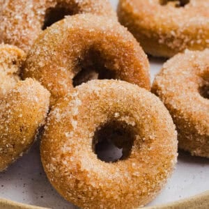 Soft Baked Apple Cider Donuts made healthier with whole wheat flour, applesauce and Greek yogurt for the perfect fall treat that comes together in just 20 minutes!  Loaded with warm spices and coated with cinnamon and sugar!