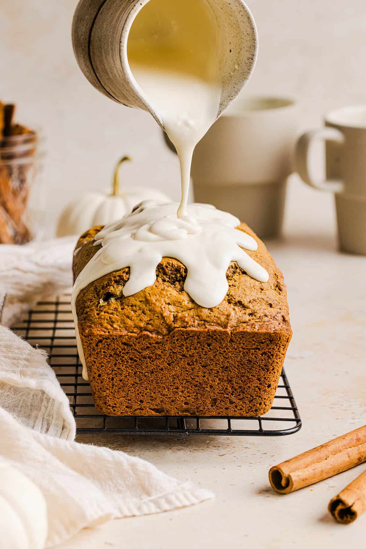 The BEST Healthy Pumpkin Bread that is moist, loaded with pumpkin flavor and made without any butter or refined sugar! Topped with a delicious maple cream cheese glaze for the perfect fall treat this season!